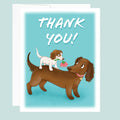 Cartoon card with two dogs and 'THANK YOU!' text on a blue background. ©Good Dharma Design by Zoe Ranucci