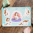 Set of yoga-themed dog stickers on a wooden surface with crystals.