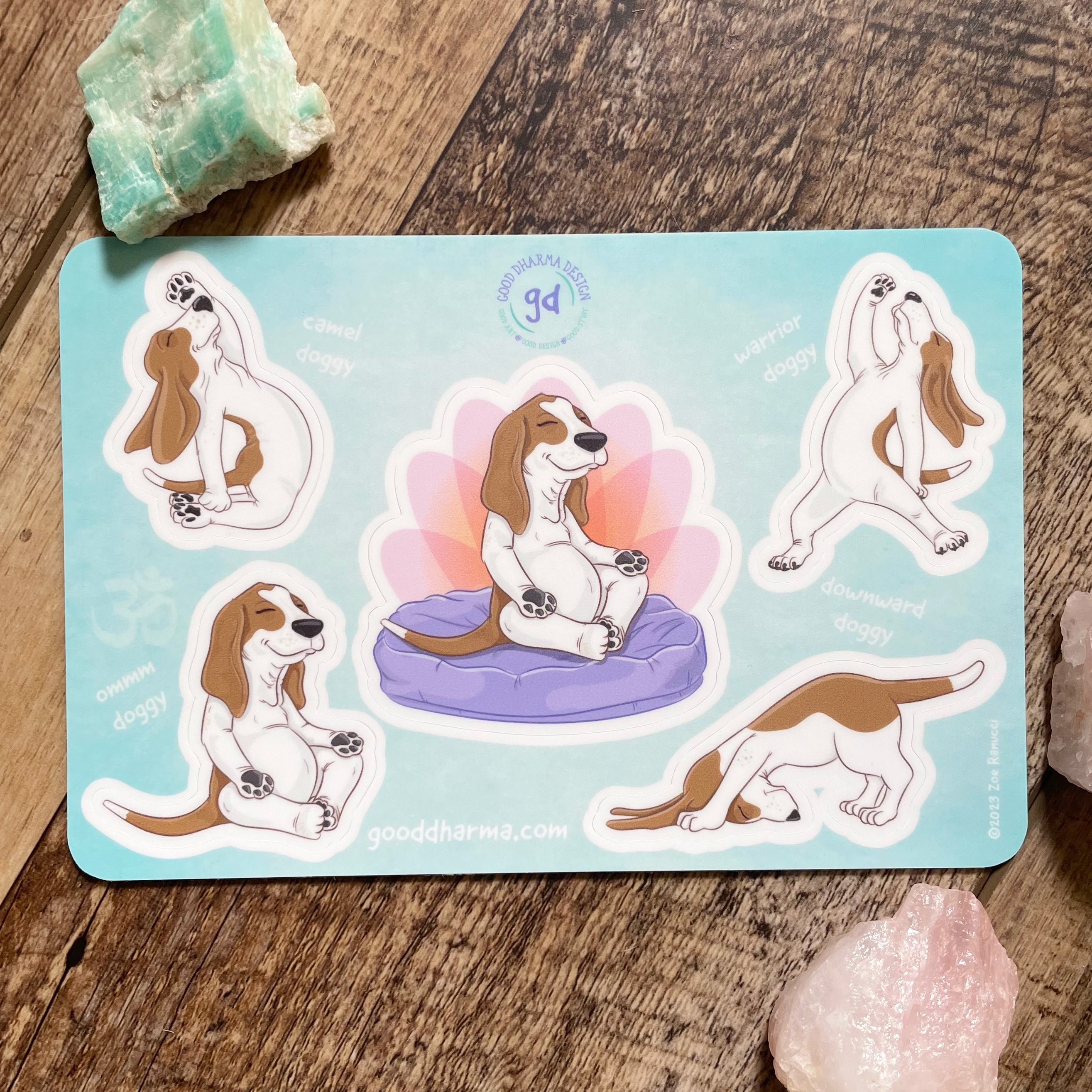 Set of yoga-themed dog stickers on a wooden surface with crystals.