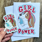 Sticker and card with 'Girl Power' design on a wooden surface