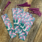 Set of bookmarks with axolotl design on a wooden surface