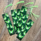 Set of green bookmarks with tassels on a wooden surface