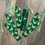 Green bookmarks with tassels on a wooden surface