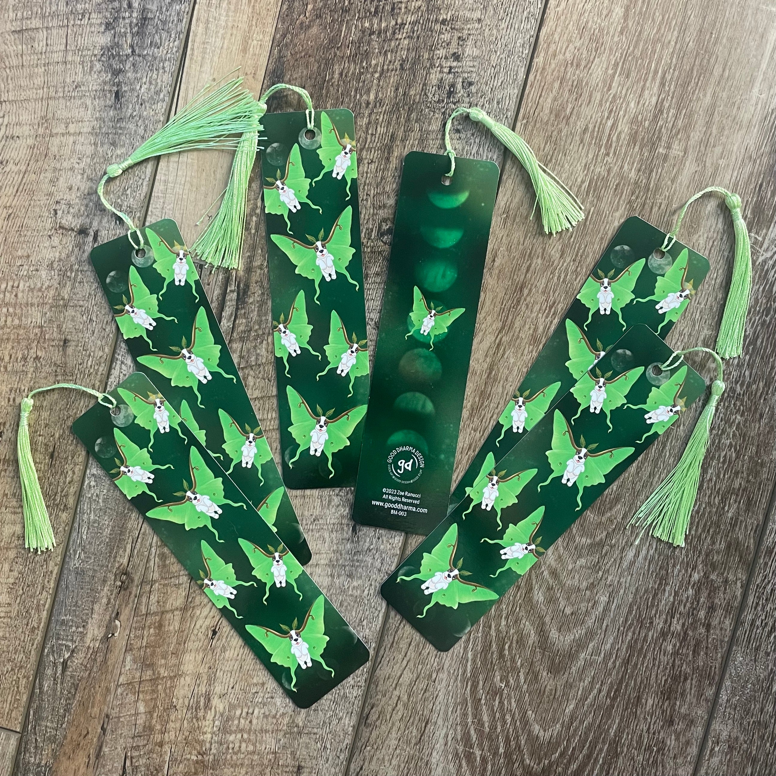 Green bookmarks with tassels on a wooden surface