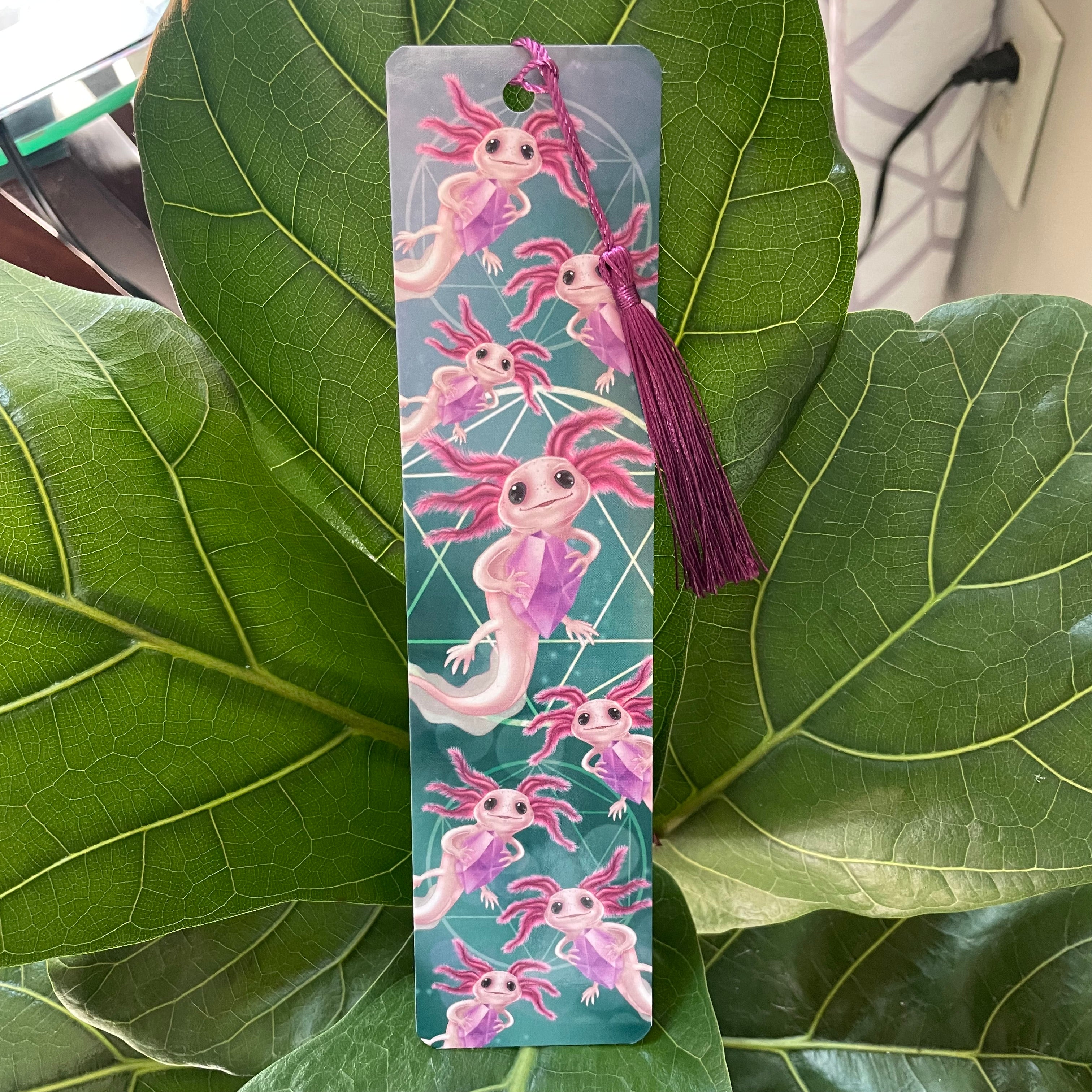 Bookmark with axolotl design on a green leaf background