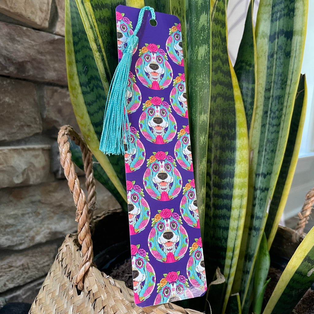Colorful bookmark with dog design on a purple background, placed on a plant