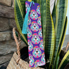 Colorful bookmark with dog design on a purple background, placed on a plant