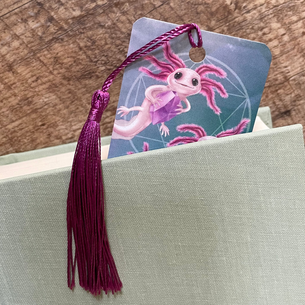 Axolotl bookmark with tassel on a gray surface
