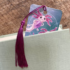 Axolotl bookmark with tassel on a gray surface