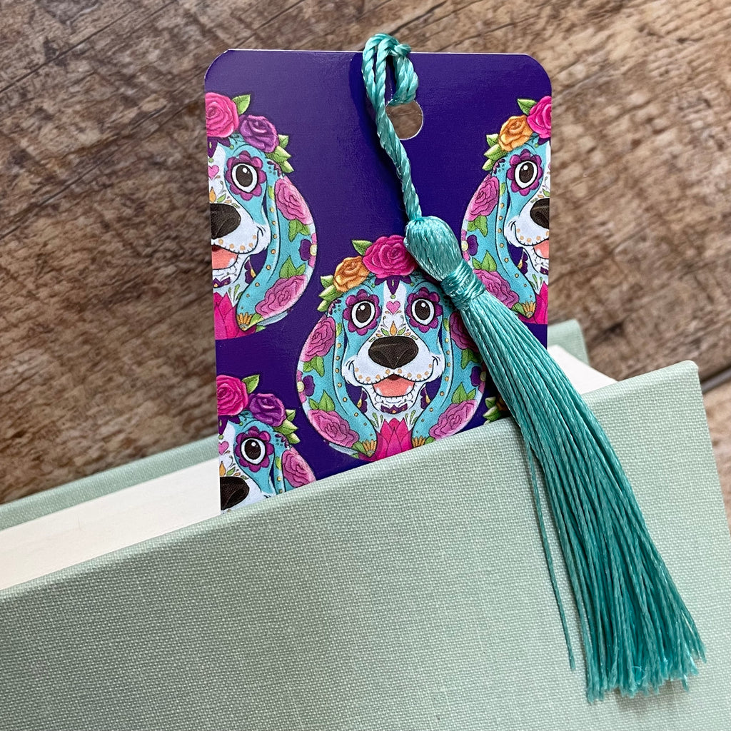 Colorful dog-themed bookmark with tassel on a wooden surface