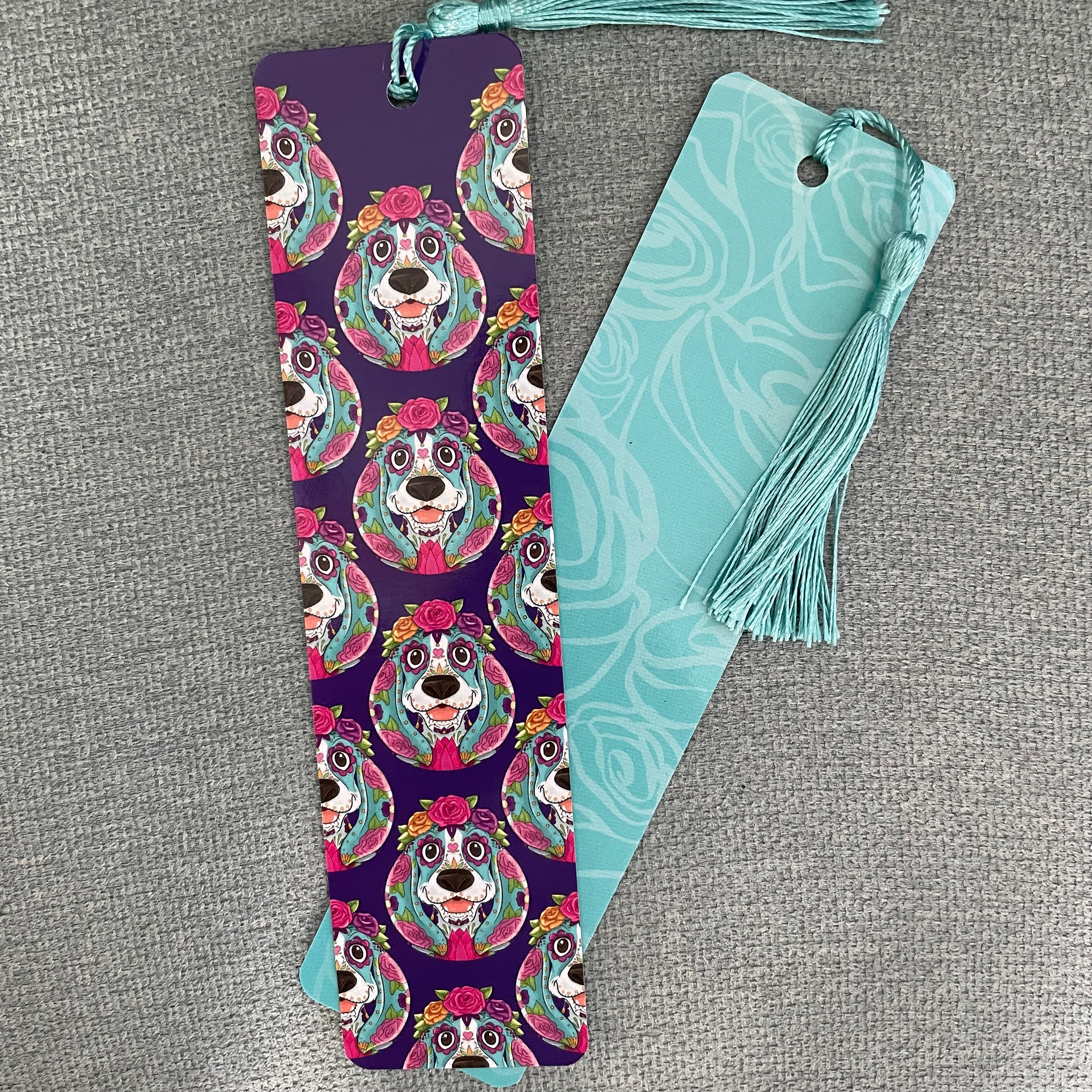 Two bookmarks with colorful designs on a gray textured surface