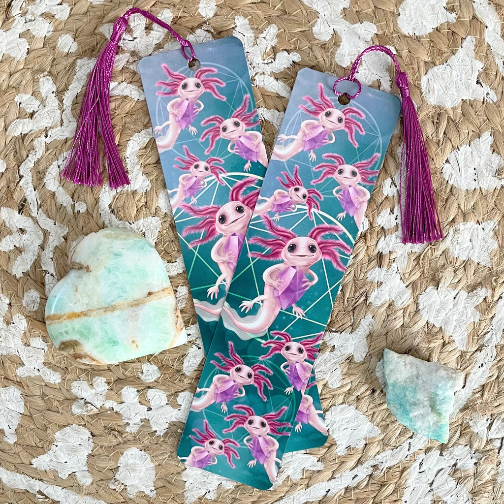 Two colorful bookmarks with axolotl designs on a textured surface with crystals.