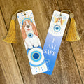 Two bookmarks with dog illustrations and tassels on a wooden surface