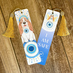 Two bookmarks with dog illustrations and tassels on a wooden surface