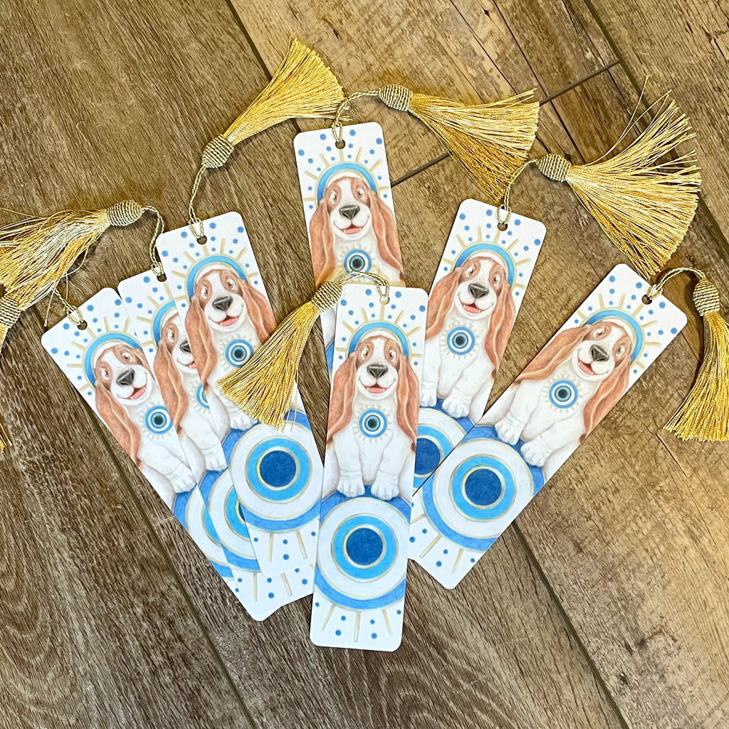 Set of bookmarks with dog illustrations and tassels on a wooden surface. ©Good Dharma Design by Zoe Ranucci